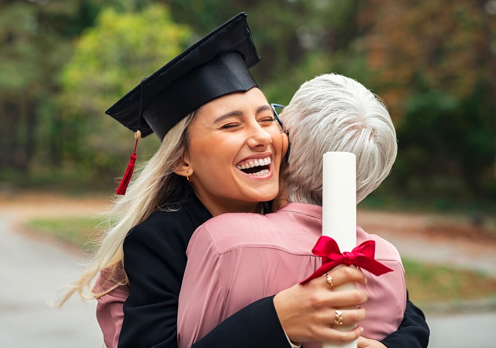 Jeune graduée serrant une grand-mère dans ses bras