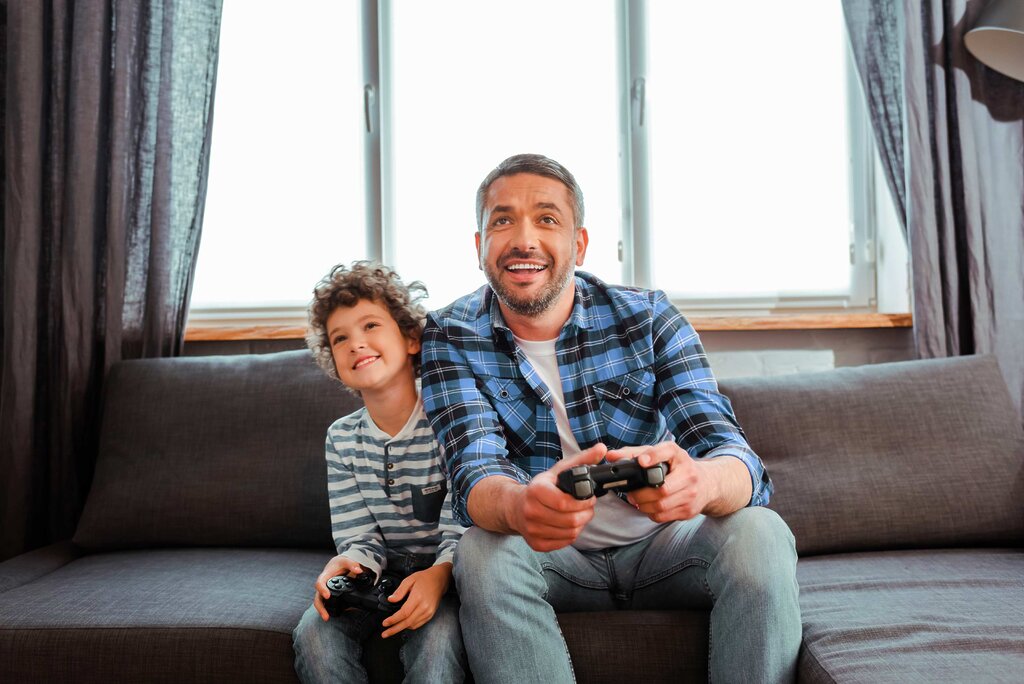Père et fils jouant à la console vidéo