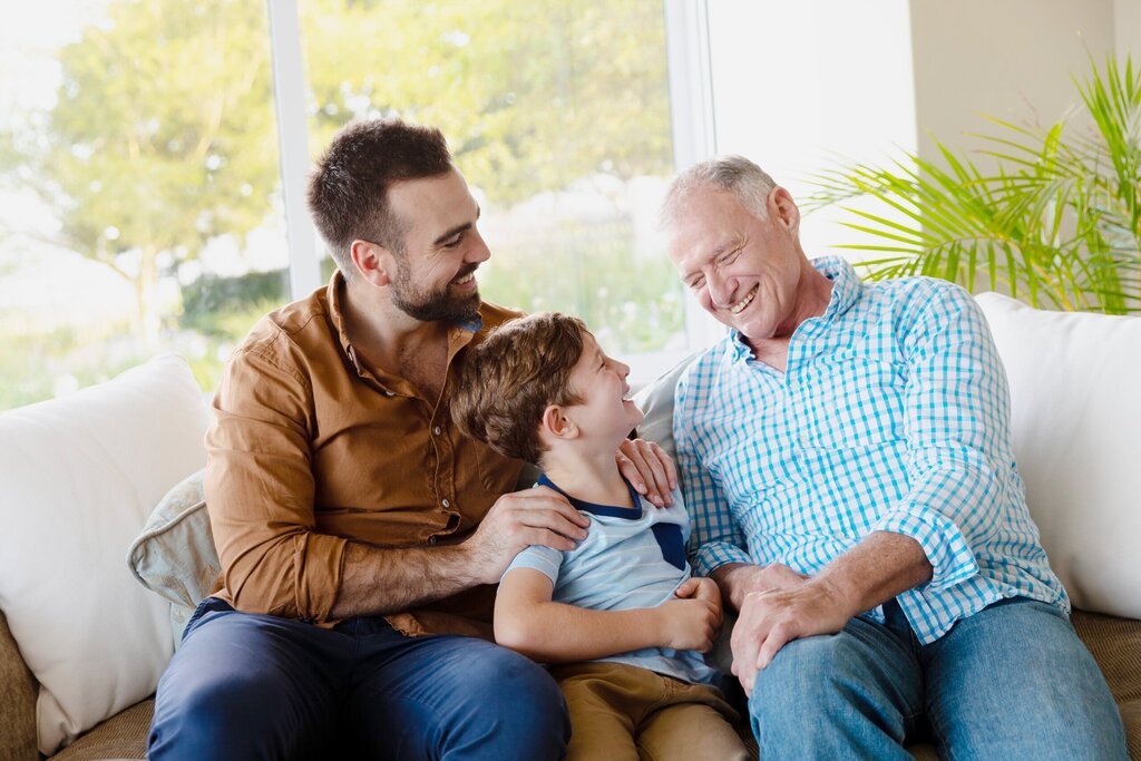 Grand-père-, père et garçon riant sur le divan