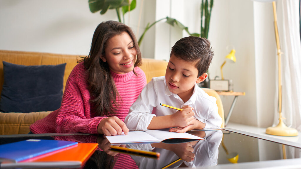 Femme aide un garçon avec ses devoirs