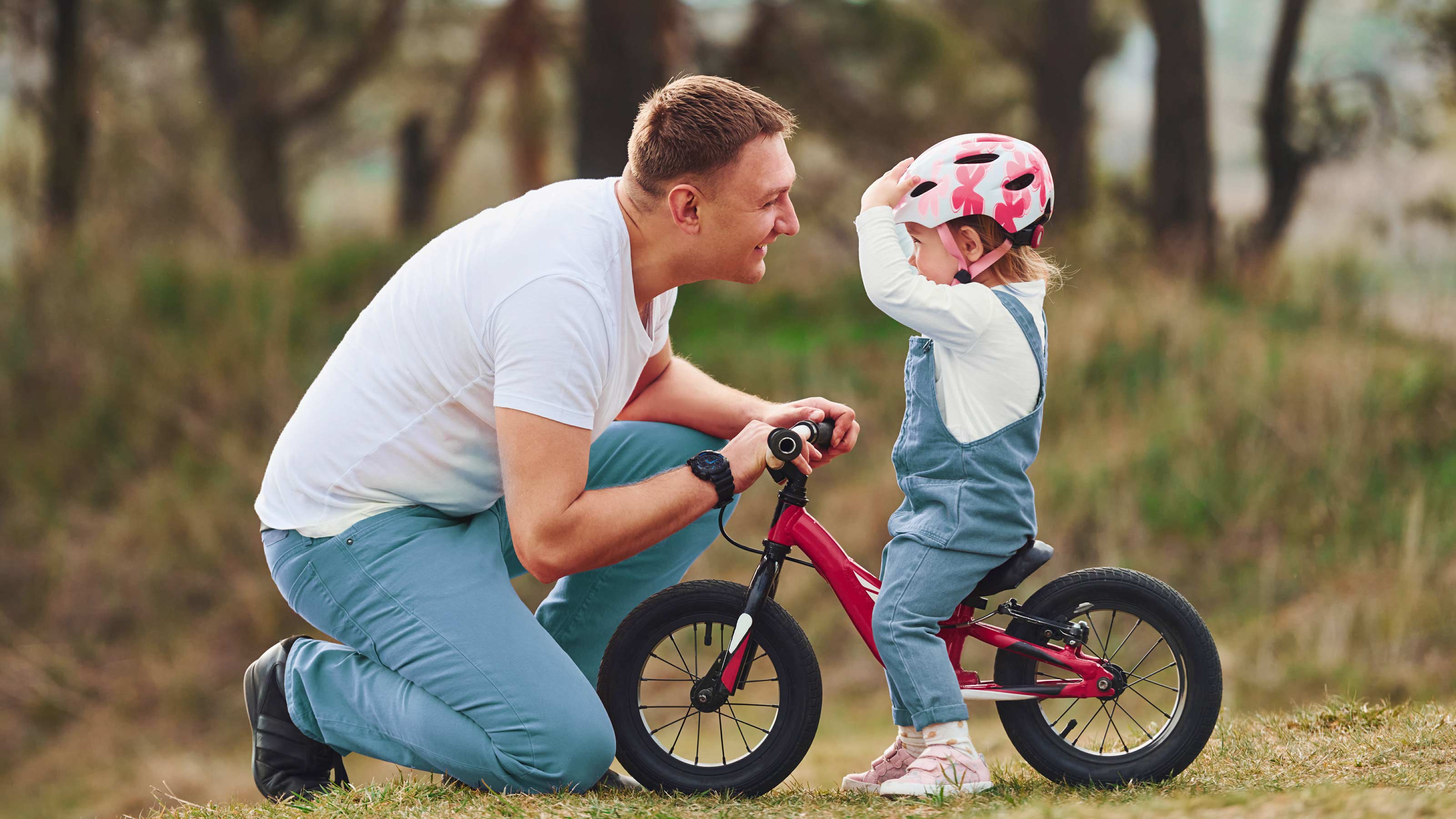 Homme aidant un enfant à vélo