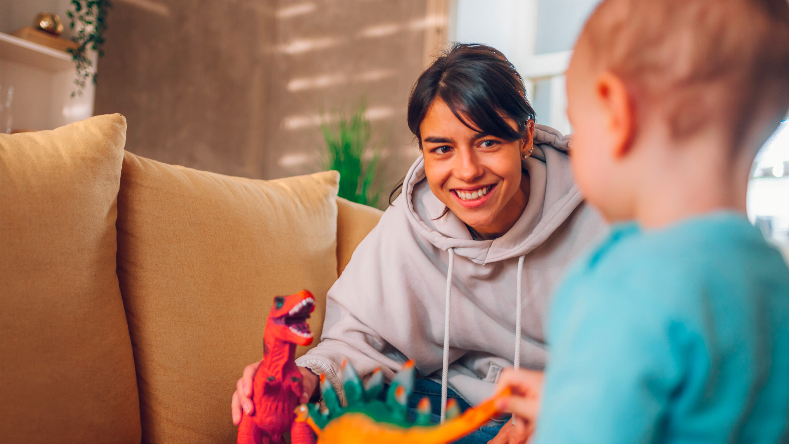 Mère qui joue avec la peluche dinosaure de son enfant