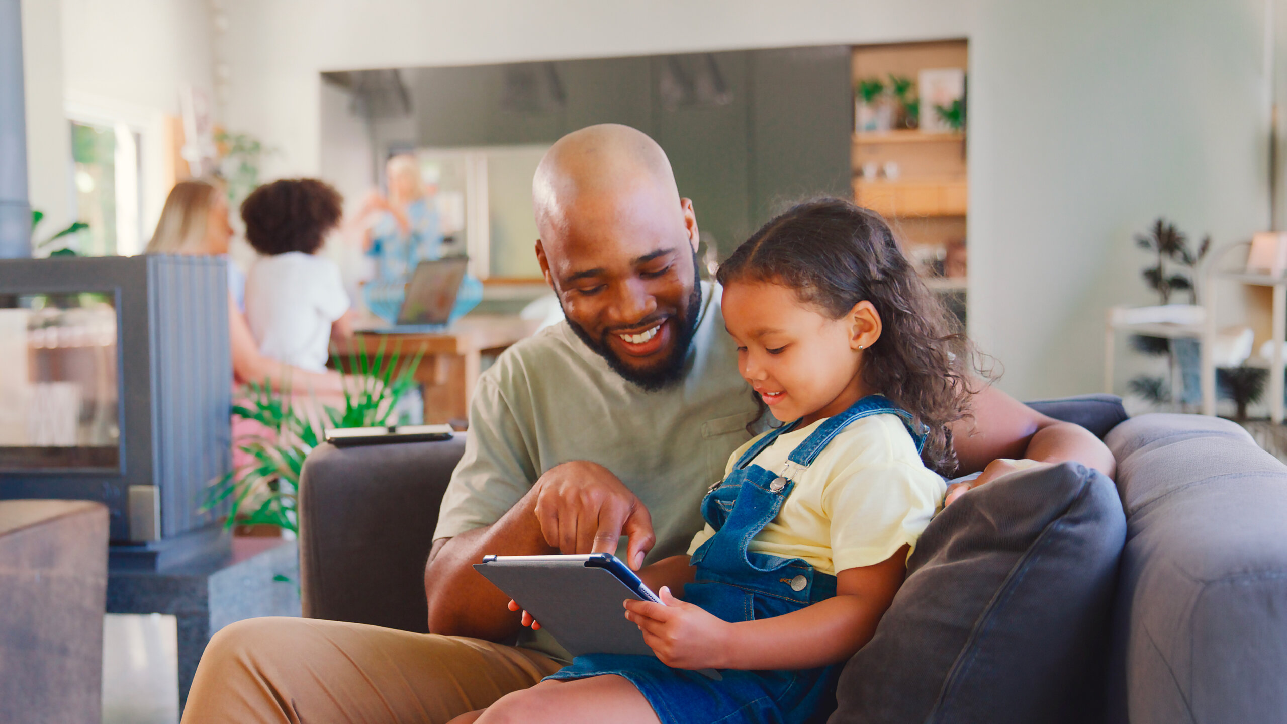 Père avec sa fille jouant sur une tablette