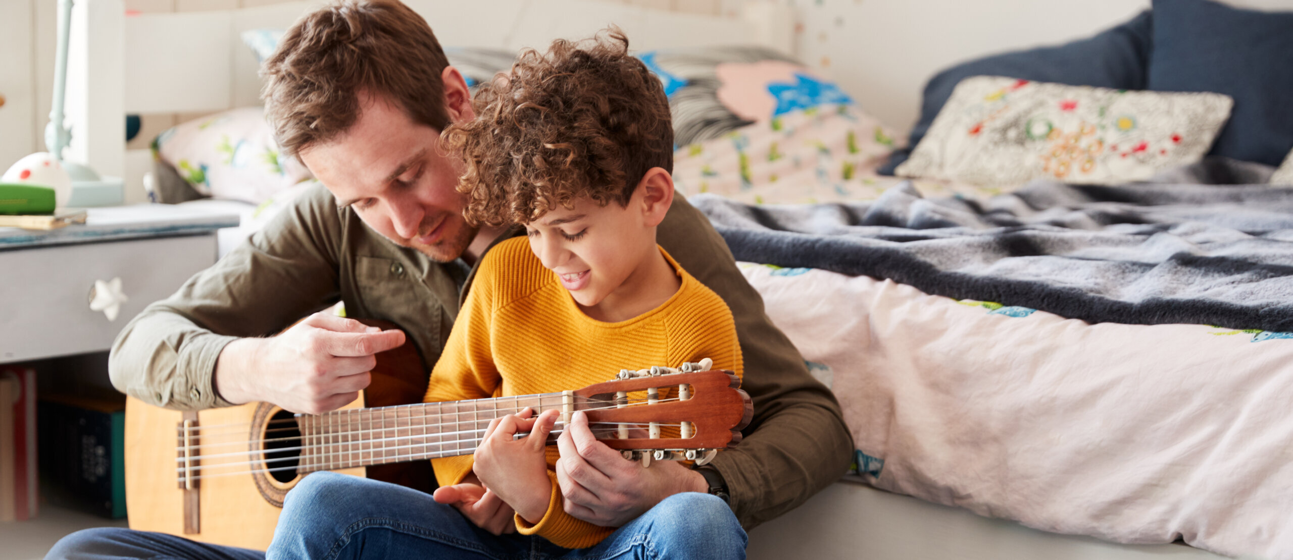Père et son fils qui jouent de la guitare